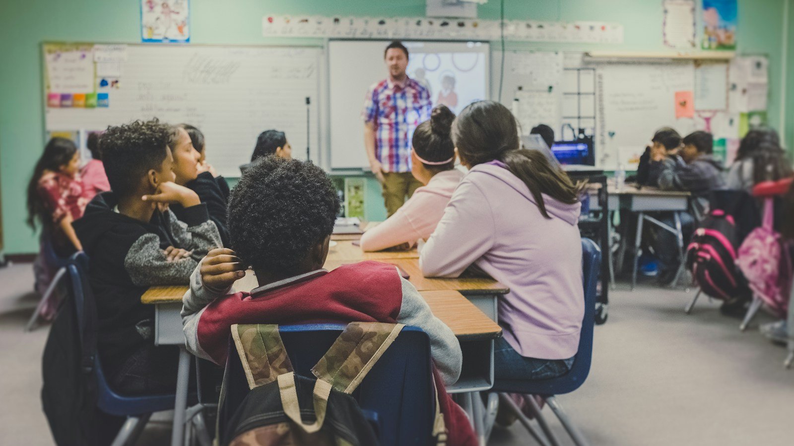 Teacher leading a class of students in a classroom