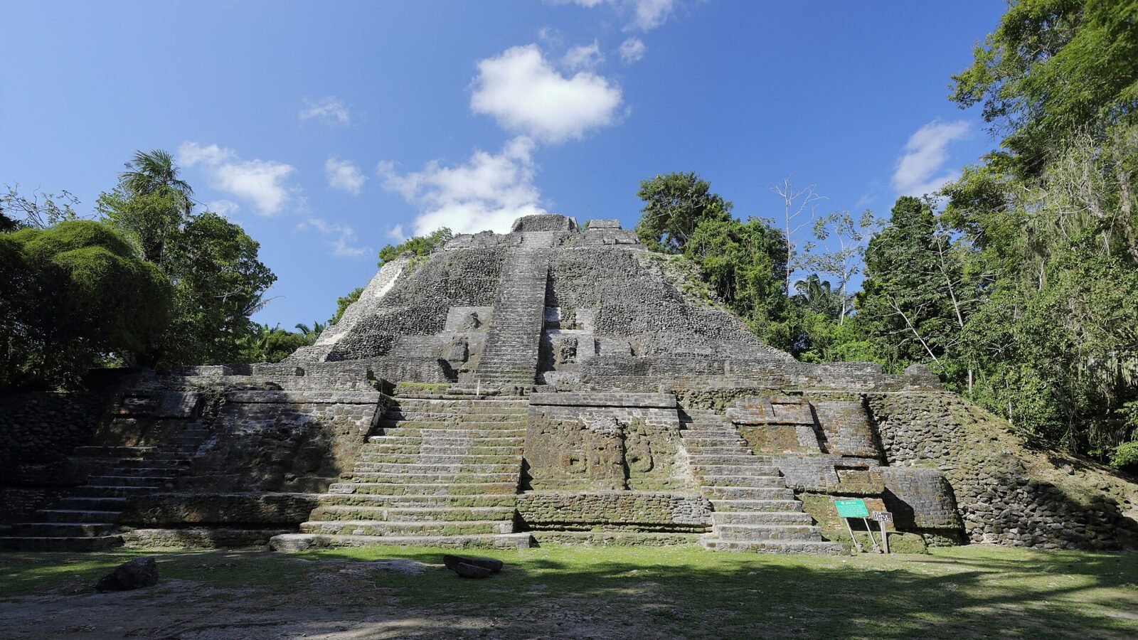 Lamanai’s High Temple rising above a clearing in Belize’s tropical forest. Photo by Martin Falbisoner, CC BY-SA 4.0.