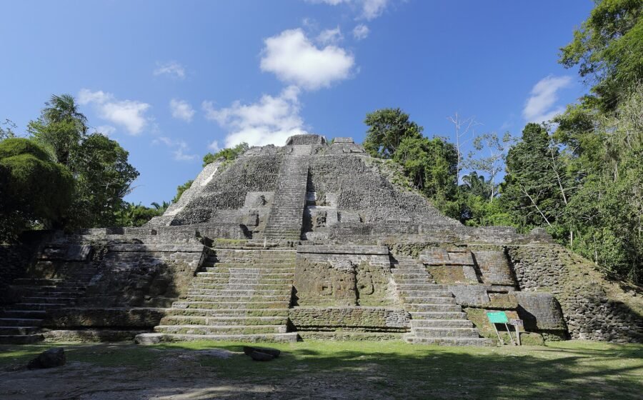 Lamanai’s High Temple rising above a clearing in Belize’s tropical forest. Photo by Martin Falbisoner, CC BY-SA 4.0.