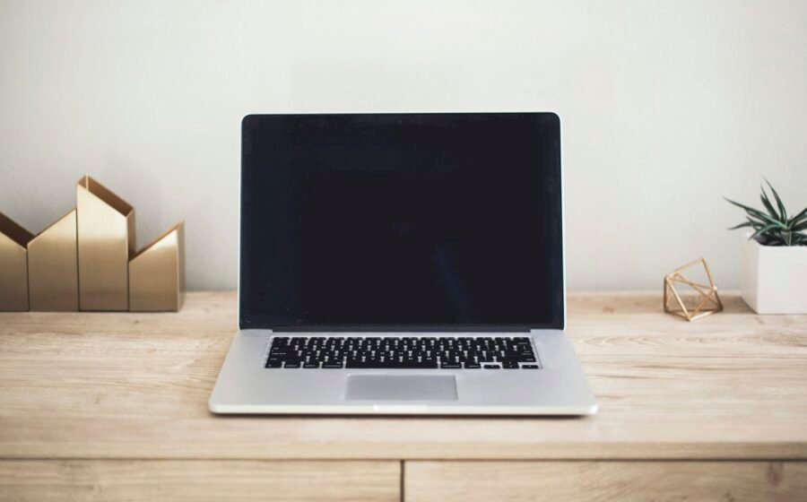 An open laptop on a wooden work surface, used as an illustrative business-computing photograph.