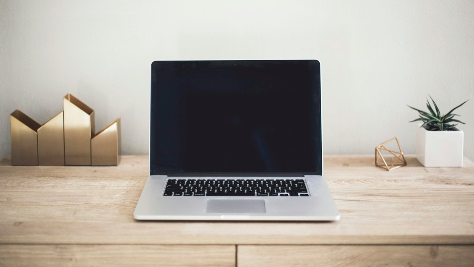 An open laptop on a wooden work surface, used as an illustrative business-computing photograph.
