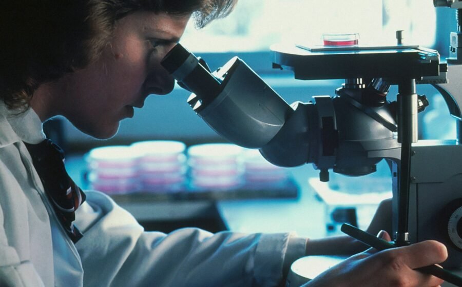 Illustrative photograph of a scientist using a microscope; not a Khemetic Biotech laboratory or claimed cancer breakthrough