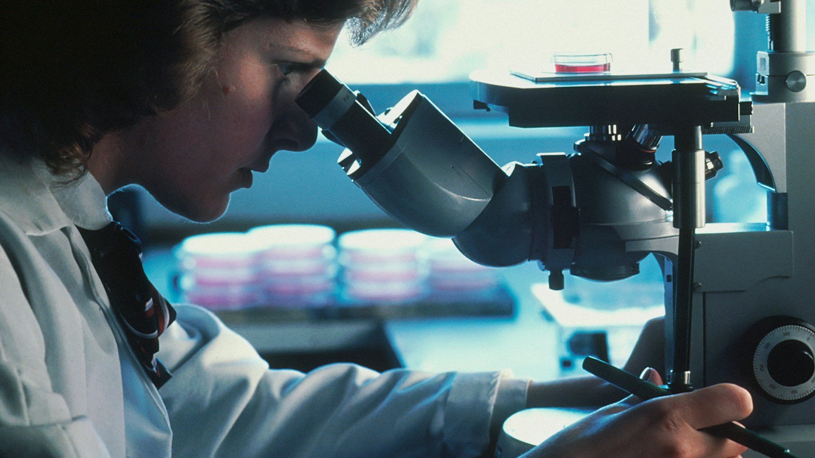 Illustrative photograph of a scientist using a microscope; not a Khemetic Biotech laboratory or claimed cancer breakthrough