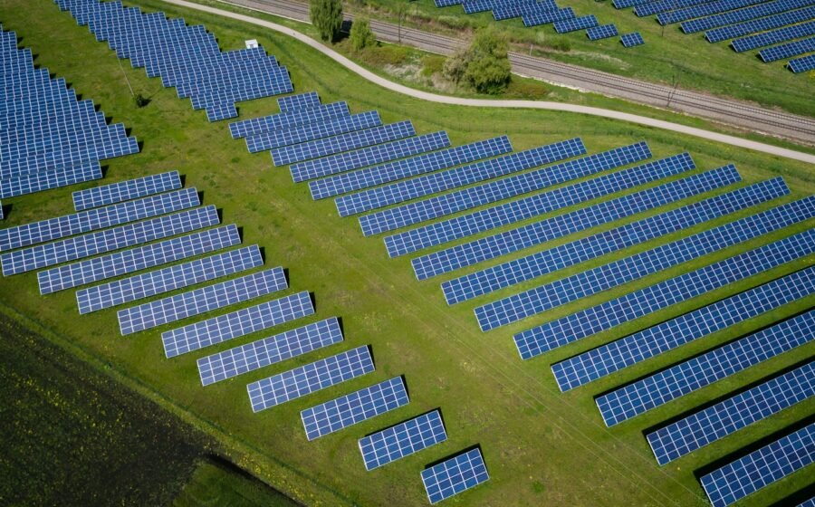 Aerial view of solar panels in a grassy landscape, representing renewable energy in future sustainable communities; illustrative, not a Khemetic Nation development.